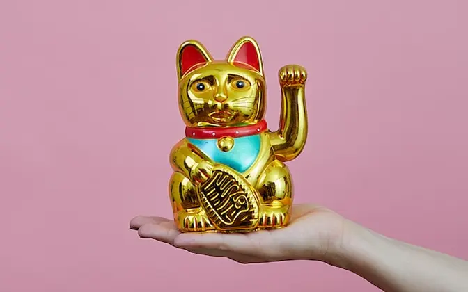 手の上に招き猫を乗せてる写真