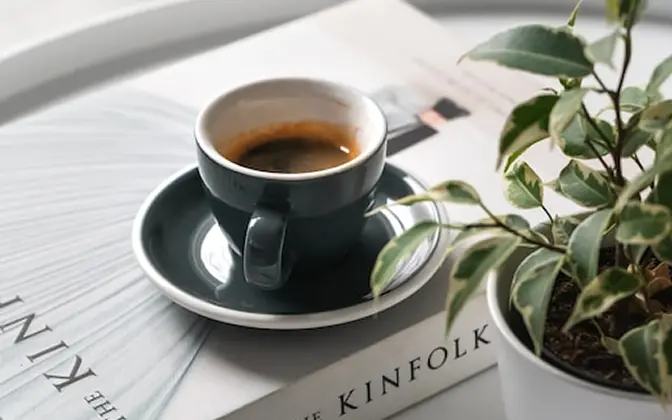書籍の上にコーヒーが乗ってる写真